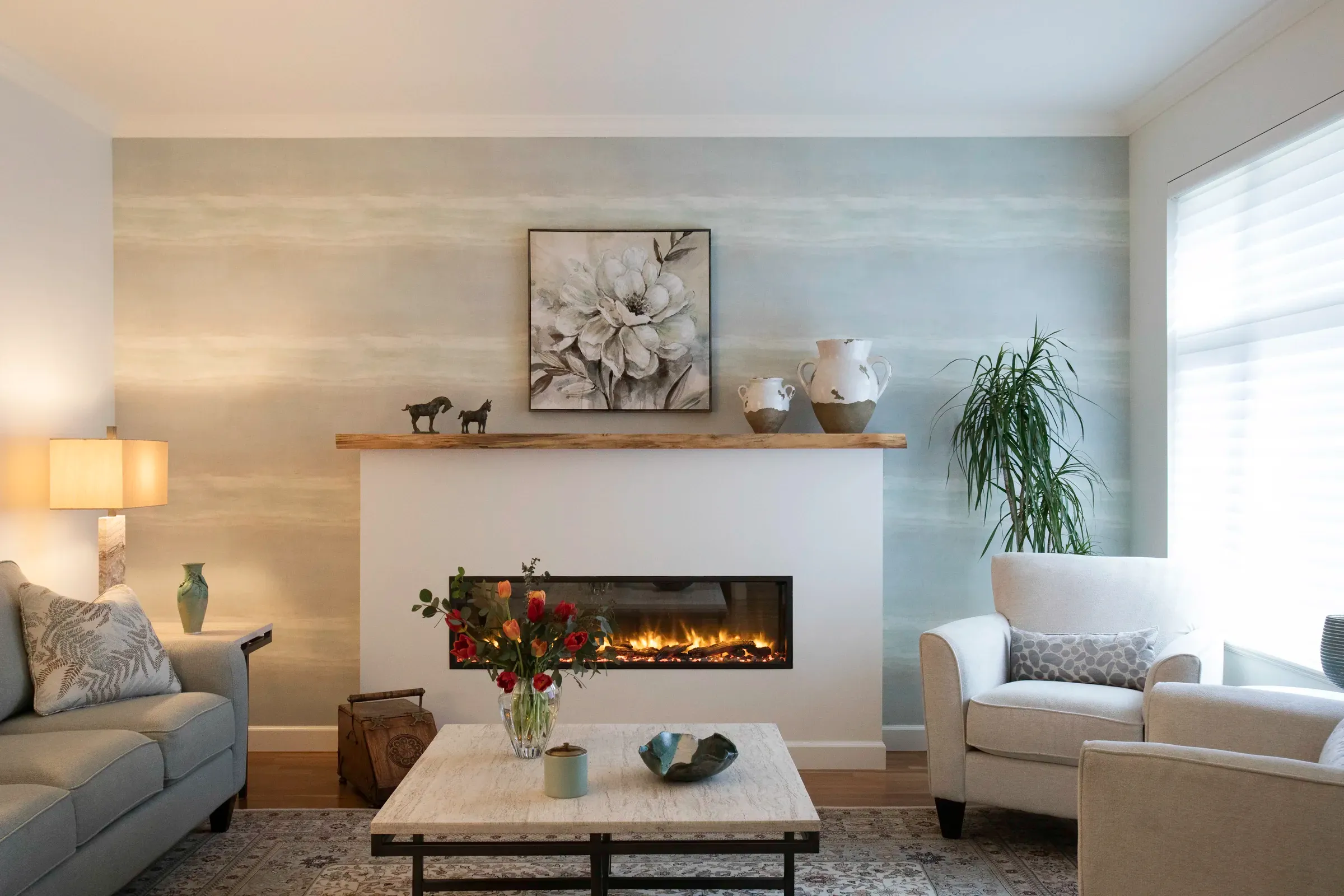 A finished living room with a softly patterned feature wall and fireplace