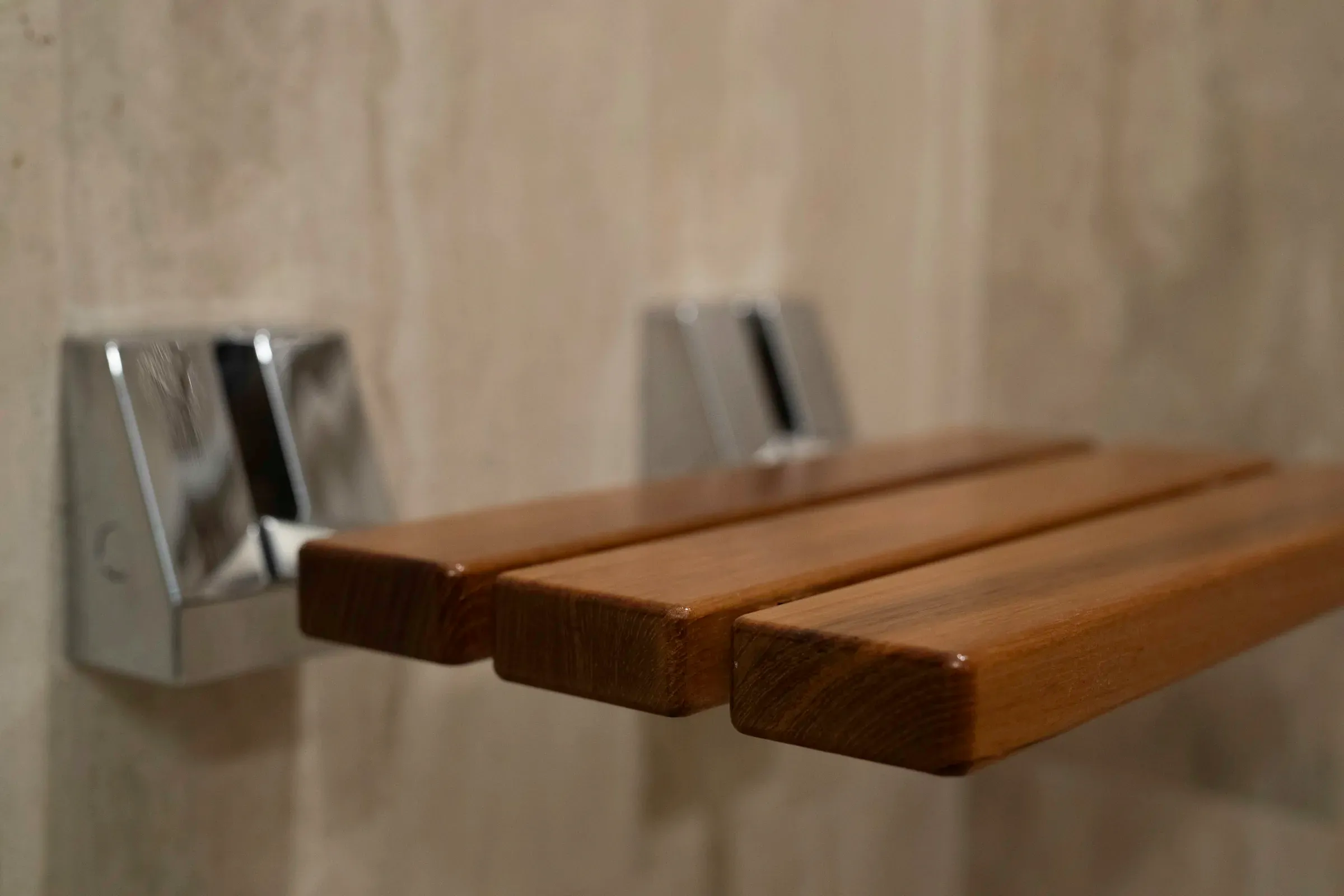 Warm wood shower bench with modern wall-mounted brackets