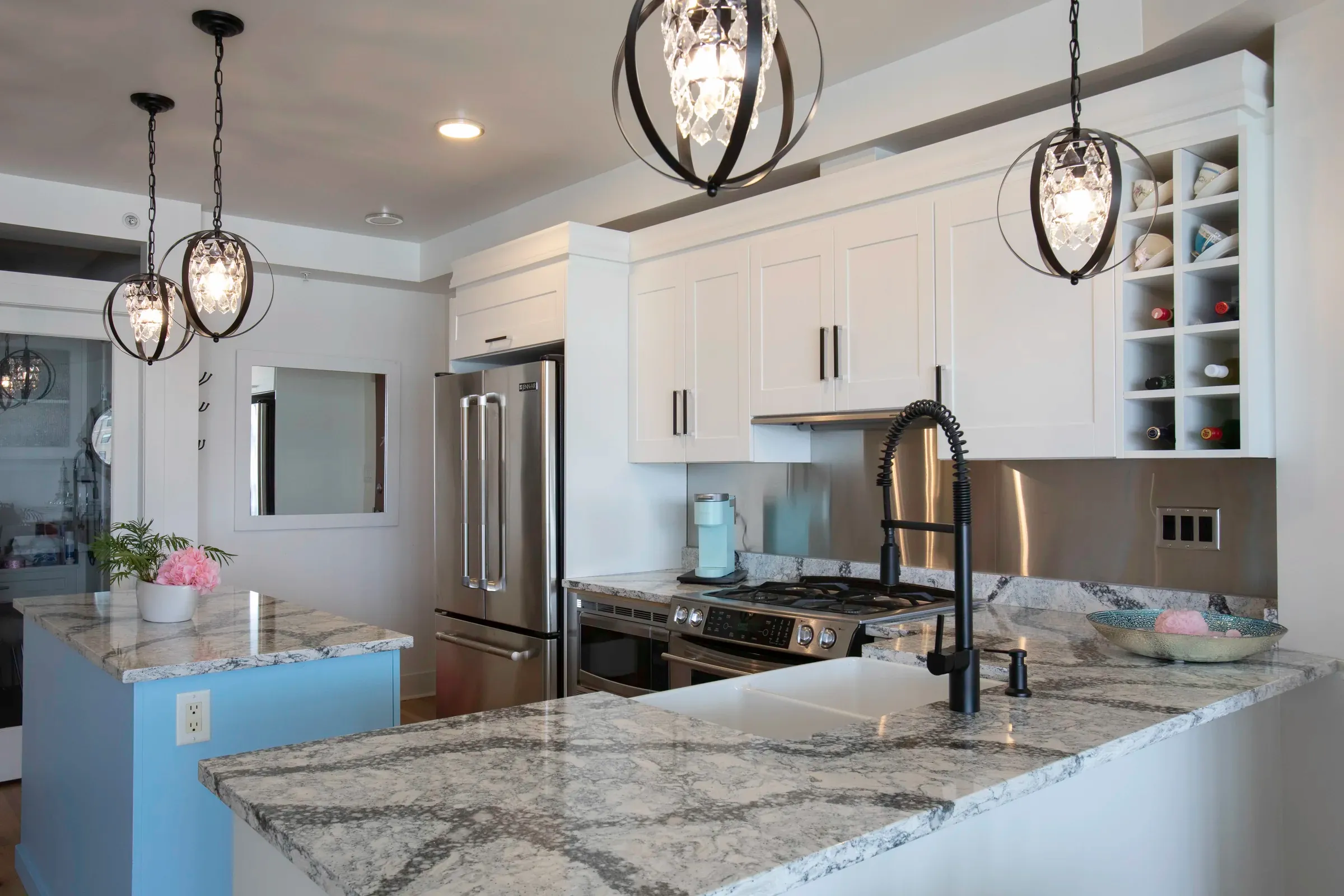 White kitchen with stone counters and black pendant lights